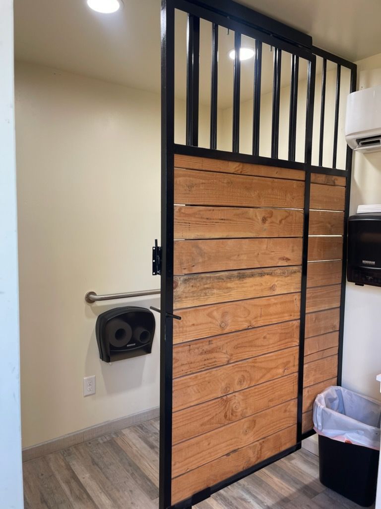 Black metal-and-wood gate divider in a small indoor utility area.
