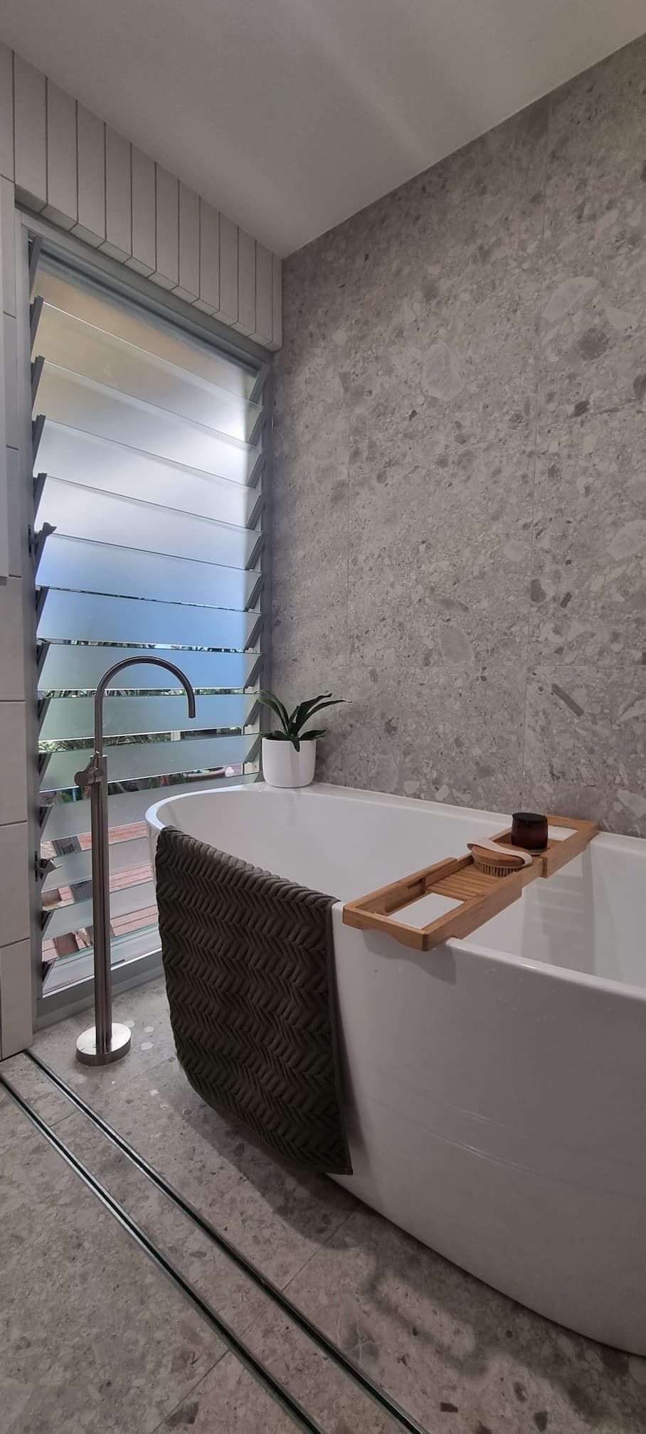 A bathroom with a bathtub and a window.