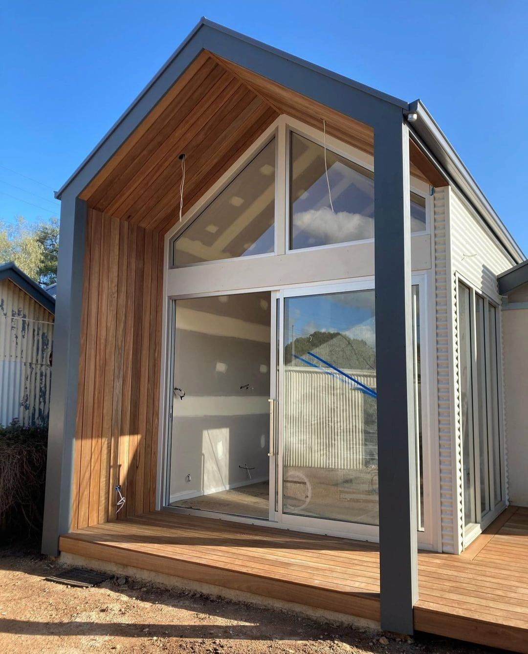 A small house with a wooden roof and sliding glass doors.