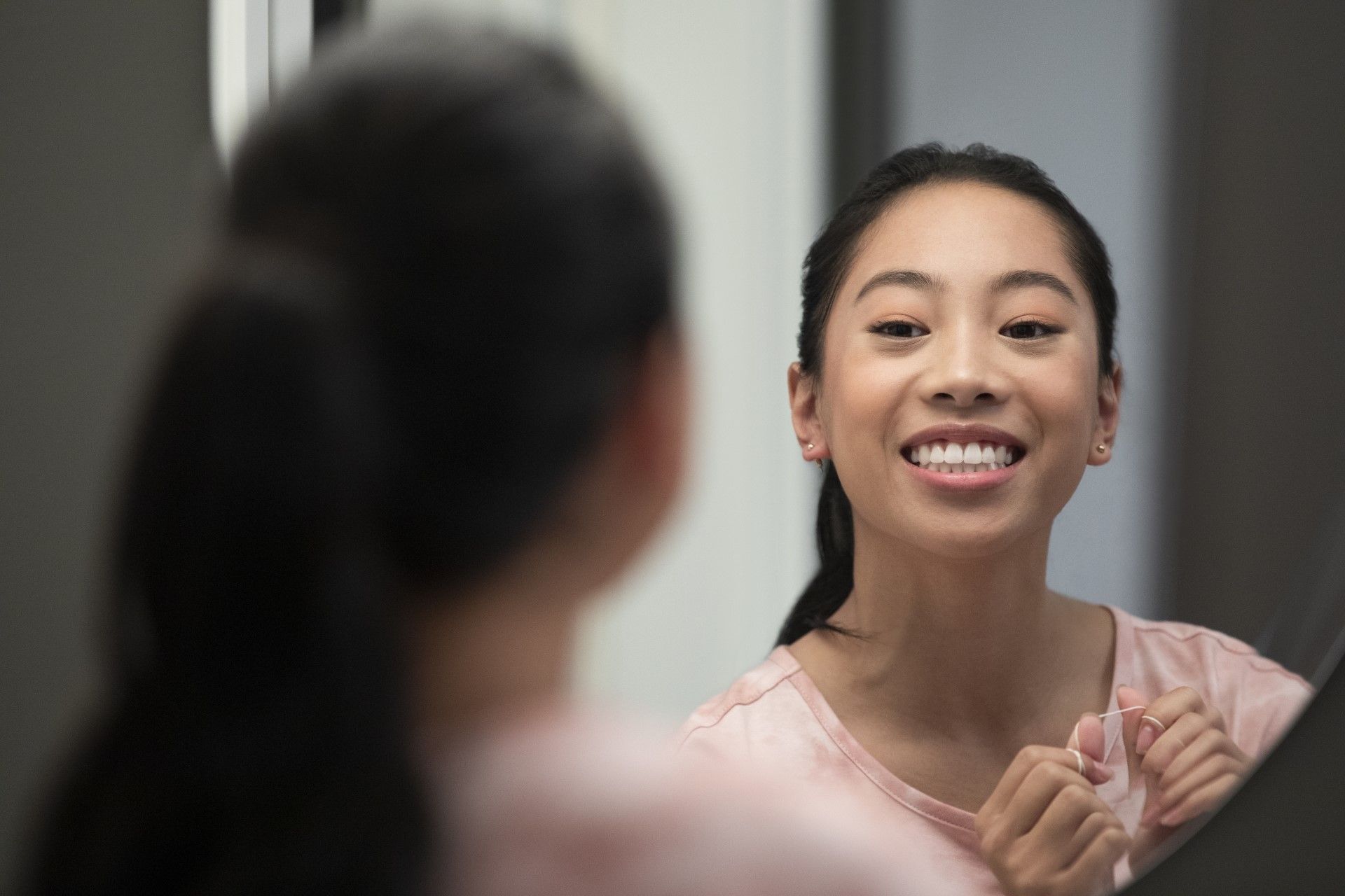 Adult smiling confidently with Invisalign clear aligners