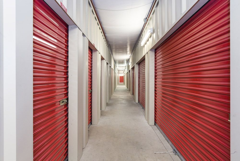 A Long Hallway with Red Doors in A Storage Facility — Bondi Removals and Taxi Trucks in Randwick, NSW