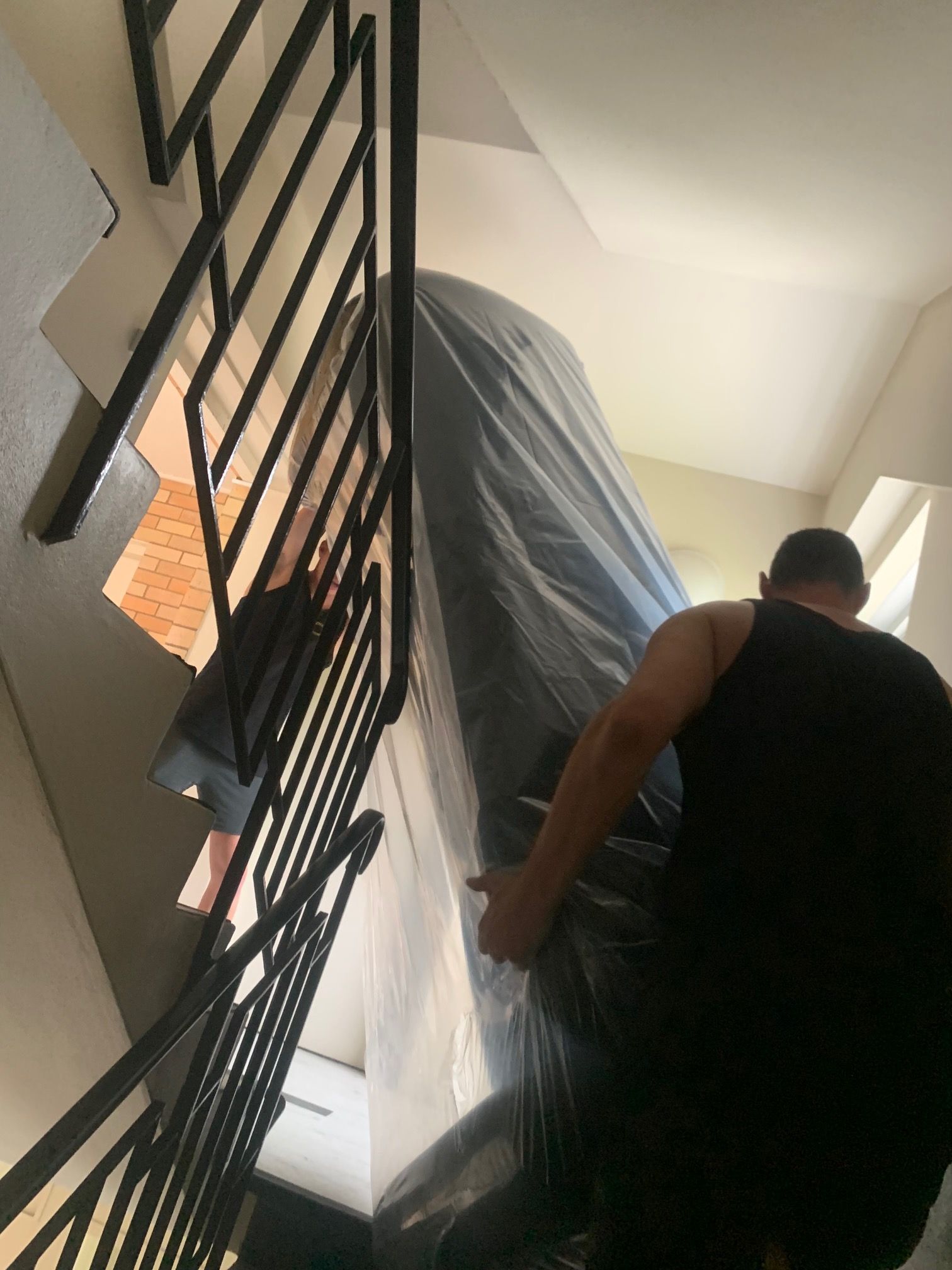 Two Movers Are Carrying a Couch up The Stairs of A Building — Bondi Removals and Taxi Trucks In Bronte, NSW