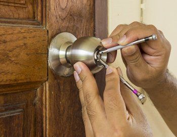 locksmith using lockpick tools to open wood door in emergency time