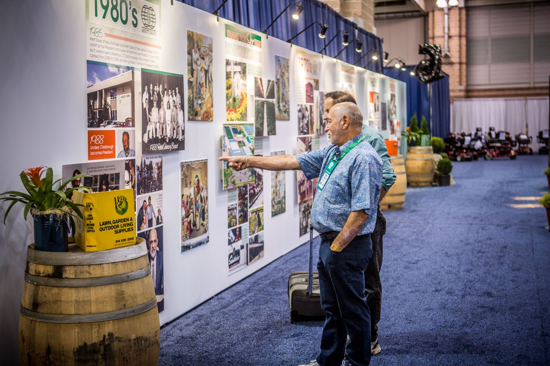 Man studying a photo exhibit on a white wall in a conference hall