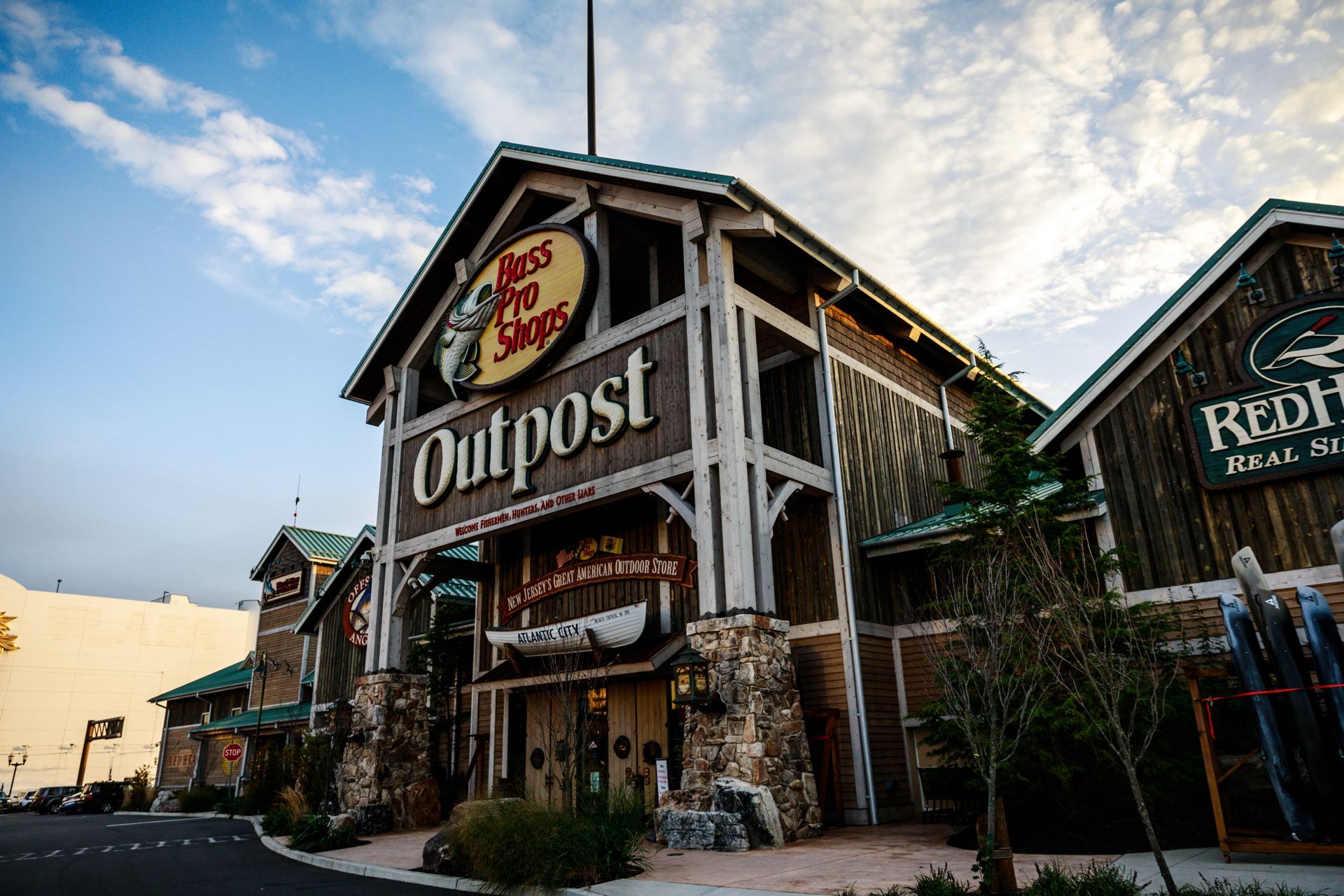 Rustic Outpost storefront with wooden facade and sign at dusk under a cloudy sky