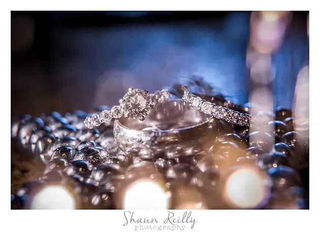 Water droplet splashing on a beaded surface, with soft blue and warm bokeh lights in the background.