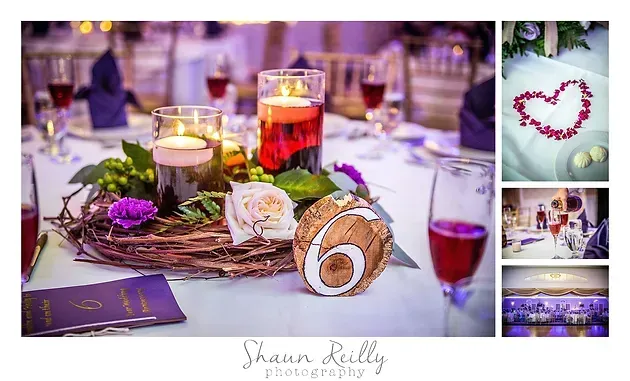 Elegant candlelit table centerpiece with purple flowers, rolled napkin, and wine glasses at a reception table