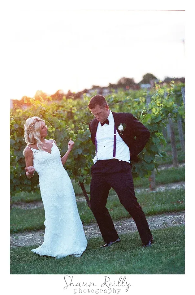 Bride and groom dancing outdoors in a vineyard at sunset