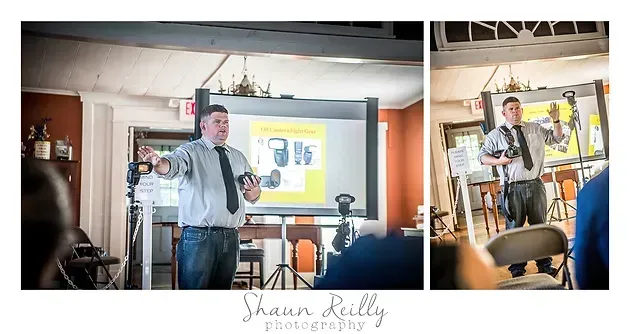 Speaker presenting indoors beside projection screen in a casual event space