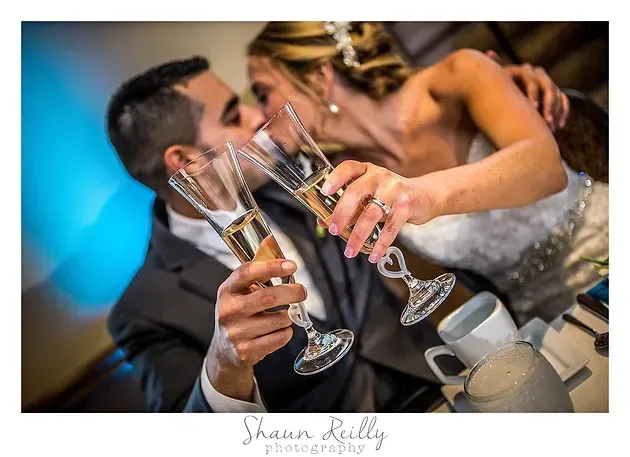 Guests clink champagne flutes at a wedding reception table