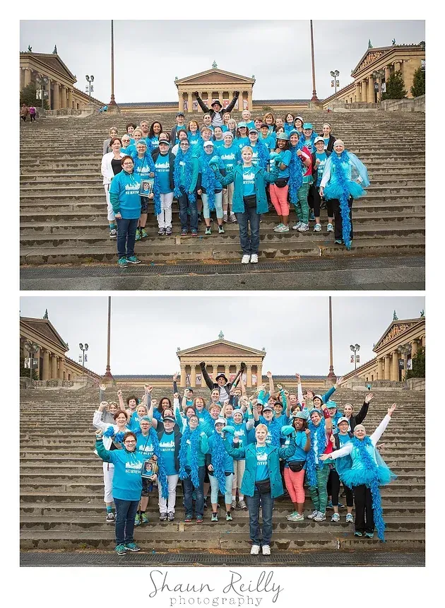 Group in blue shirts posing on wet museum steps in front of a neoclassical building.