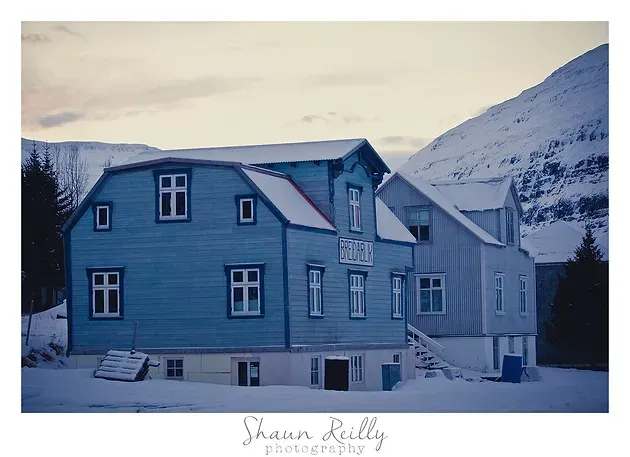 Snow-covered blue houses at dusk in a mountain village