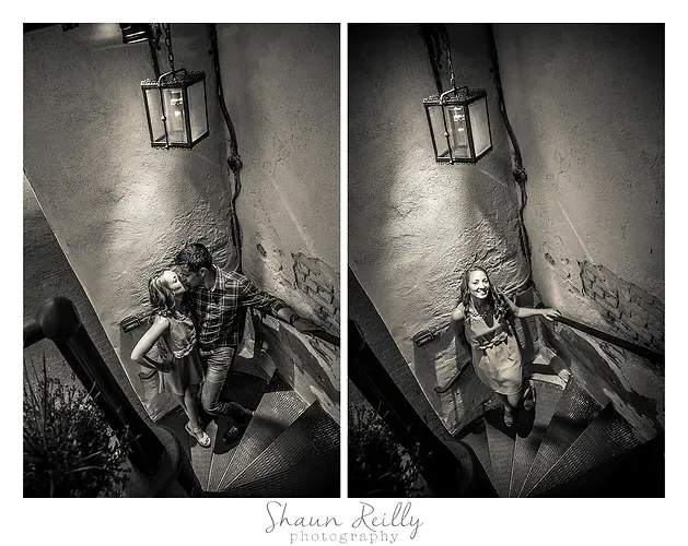 Black-and-white portrait of a person on stairs beside a hanging lantern in a narrow corner.