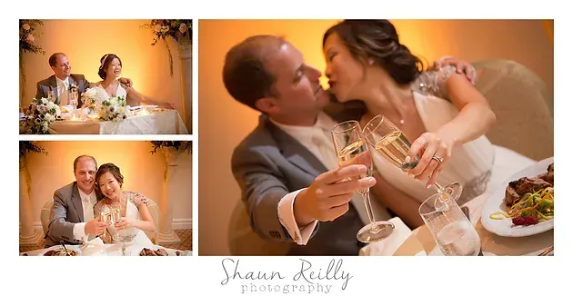 Bride and groom kissing at a wedding reception beside champagne glasses and cake￼