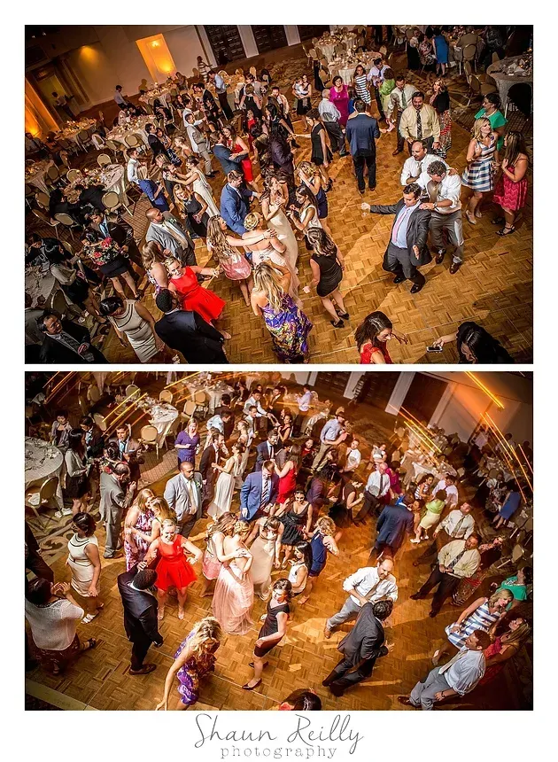 Crowded ballroom dance floor with guests dancing at a wedding reception in warm lighting