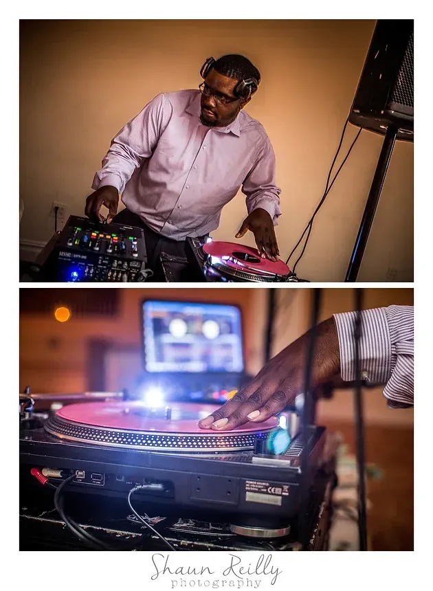 DJ mixing at a turntable setup, with a laptop and colorful lights in a warm indoor venue