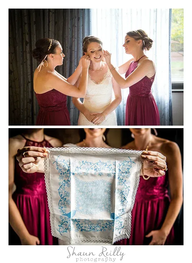 Bridesmaids help a bride in a white dress, then hold a lace garter between them.