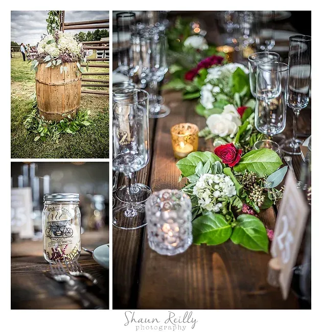Rustic wedding table decor with greenery, pink roses, candles, and glassware on a wooden table