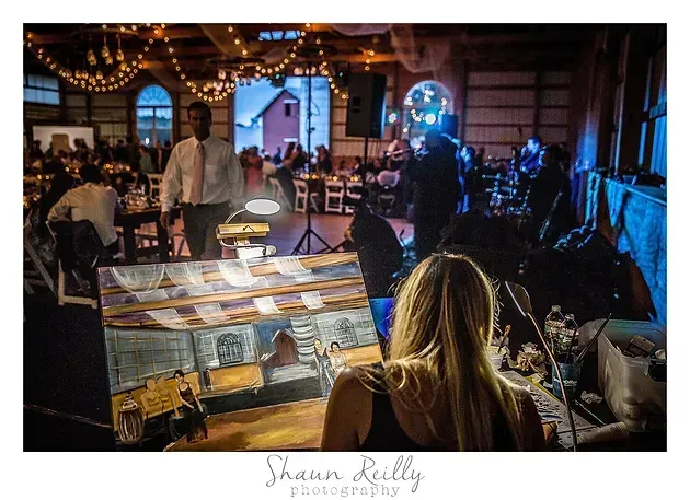 Live band performing in a warmly lit rustic venue, seen over a photographer’s camera screen.