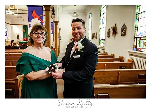 Couple holding hands during a church wedding ceremony, standing by pews and stained-glass windows