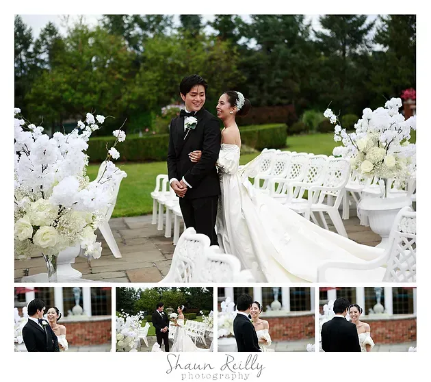 Bride and groom posing in a white outdoor wedding ceremony with floral arrangements and benches