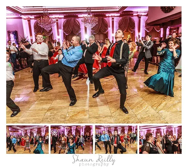 Formal dance floor with people in colorful outfits doing synchronized kicks in a pink-lit ballroom
