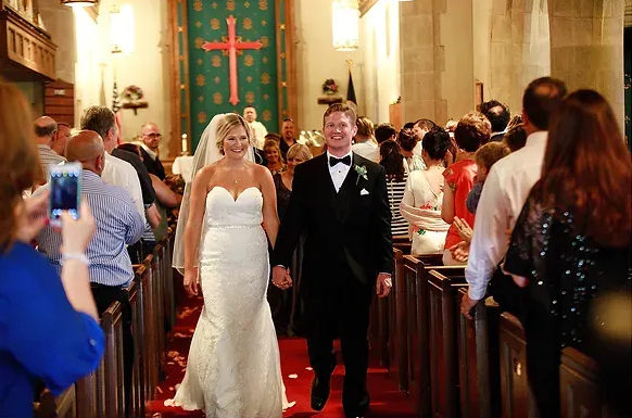 Bride and groom walking down church aisle during a wedding ceremony