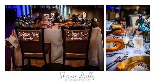 Wedding reception table with name cards, floral centerpiece, and place settings in a softly lit venue