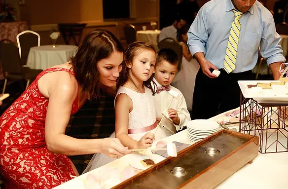Woman and two children lean over a display at a museum, examining something closely.