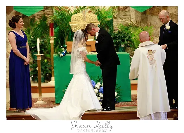Wedding couple exchanging vows in a church, with bridesmaid and officiant nearby