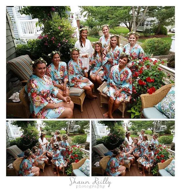 Women in floral robes posing together on garden patio furniture beside red flowers