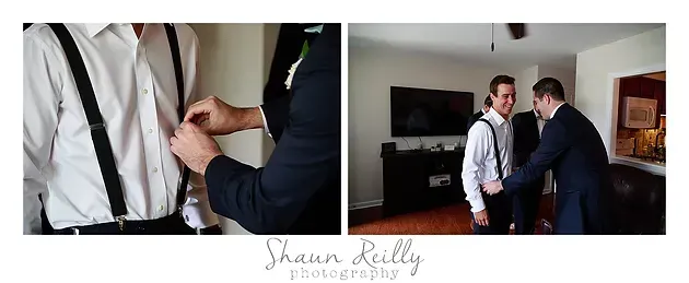 Two men in formal wear adjusting a suit jacket in a bright room with wedding photos
