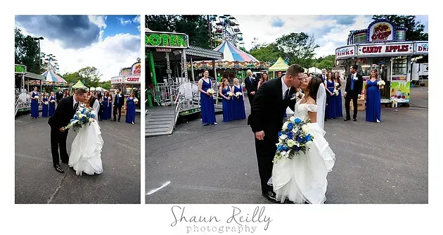 Wedding couple kissing outdoors in front of a church entrance, surrounded by guests and blue-clad attendants