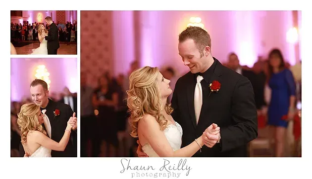 Bride and groom dancing and smiling at a wedding reception with warm pink lighting