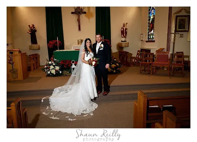Bride and groom posing in a church aisle during their wedding ceremony