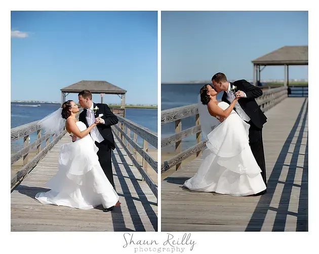 Bride and groom kissing and dancing on a pier by the water in wedding attire