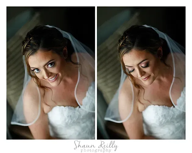 Bride in white veil and dress, smiling softly in a moody portrait.