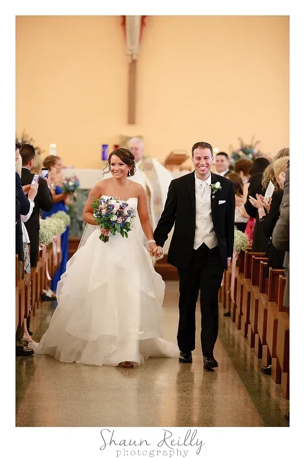 Bride and groom walking down the aisle after their wedding ceremony, guests seated on both sides