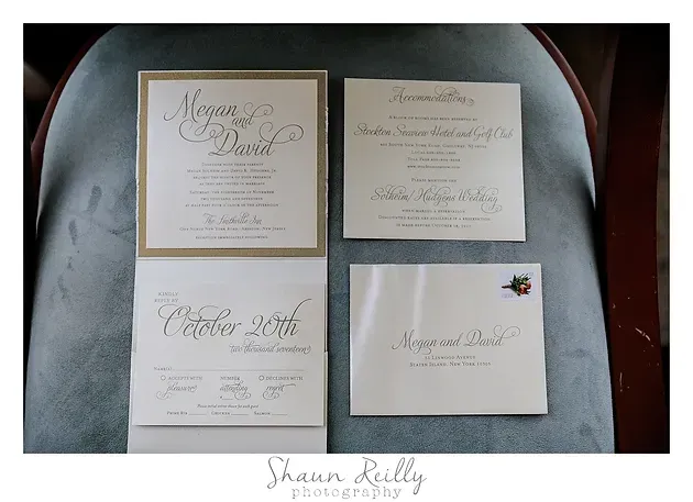 Four elegant wedding invitation cards arranged in a 2x2 grid on a dark tray.