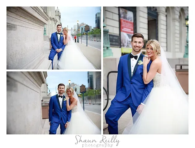 Bride and groom in blue and white wedding attire posing outdoors by a stone building