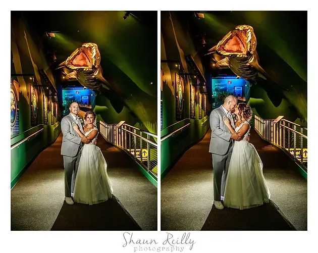 Couple posing in formal attire in a lit tunnel with a large rose sculpture overhead