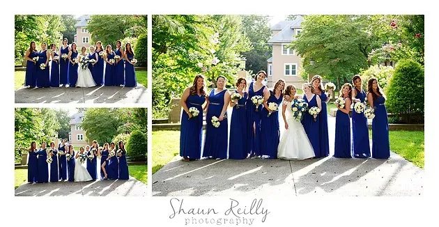 Wedding party posing outdoors in navy dresses and suits, with bride in white in the center