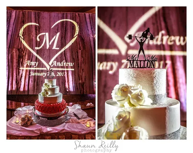 Wedding cake with pink roses and heart-shaped initials against a burgundy backdrop