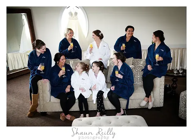 Group in blue and white robes posing on a couch in a living room