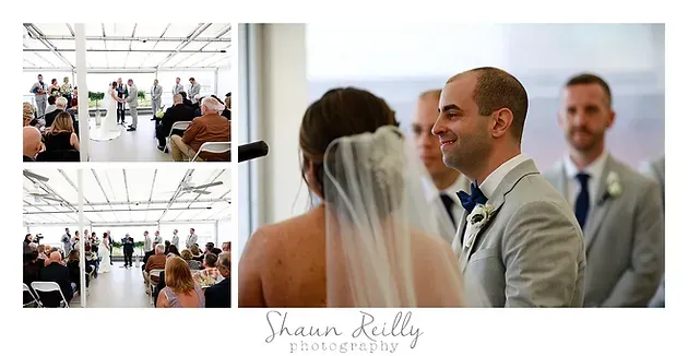Wedding ceremony with bride and groom smiling, with guests seated in a bright white venue