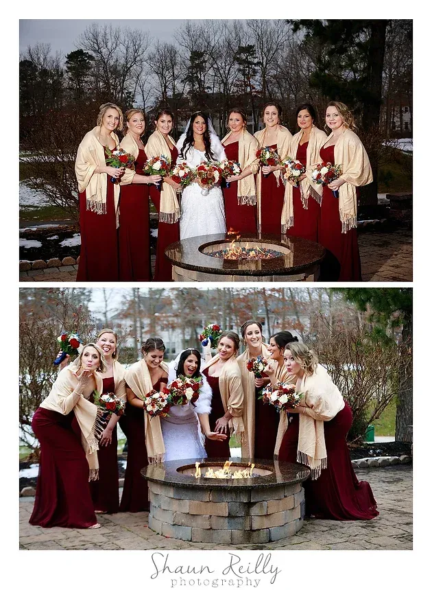 Wedding party in burgundy and cream dresses posing around an outdoor fountain in winter.