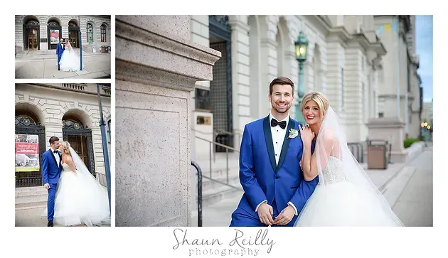 Bride and groom in blue suit and white gown posing outside a stone building