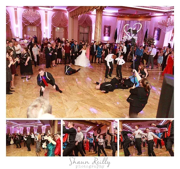 Wedding reception dance floor with guests dancing under pink lighting in a ballroom