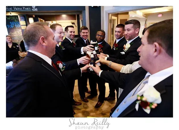 Group of people in suits toasting with champagne glasses at a formal indoor celebration