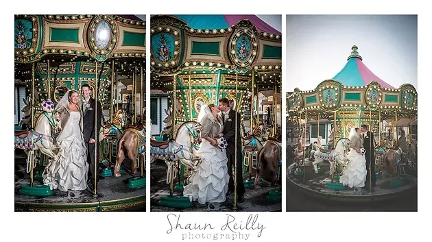 Bride and groom pose in white on a colorful carousel at dusk